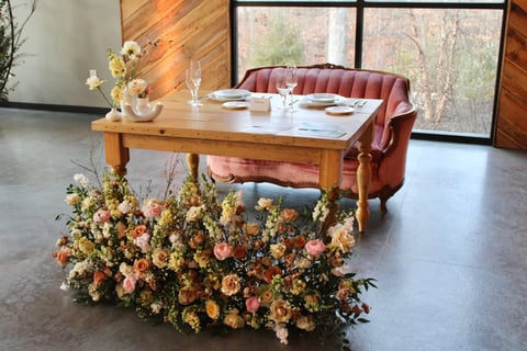 sweetheart table is decorated with a statement piece that is floral heavy