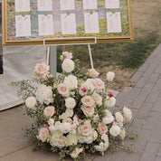 A gorgeous arrangement sits under a seating chart and a wedding