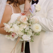 a bride and groom hold onto a bouquet of wrapped stems for their wedding in Cleveland