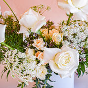 floral designers pair white roses, pale peach spray roses, purple waxflower, Queen Anne's Lace and greens