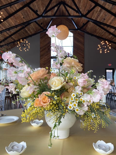 chamomile, sweet pea, ranunculus, and roses overflow a simple vase at a Cleveland wedding