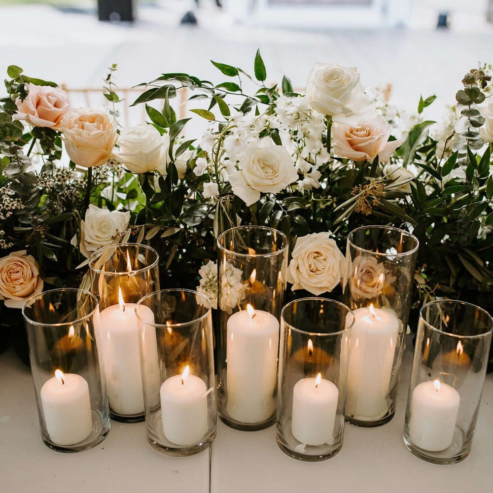 White floral table arrangement with 7 pillar candles