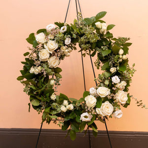 Sympany wreath with neutral flowers on an easel, close up.