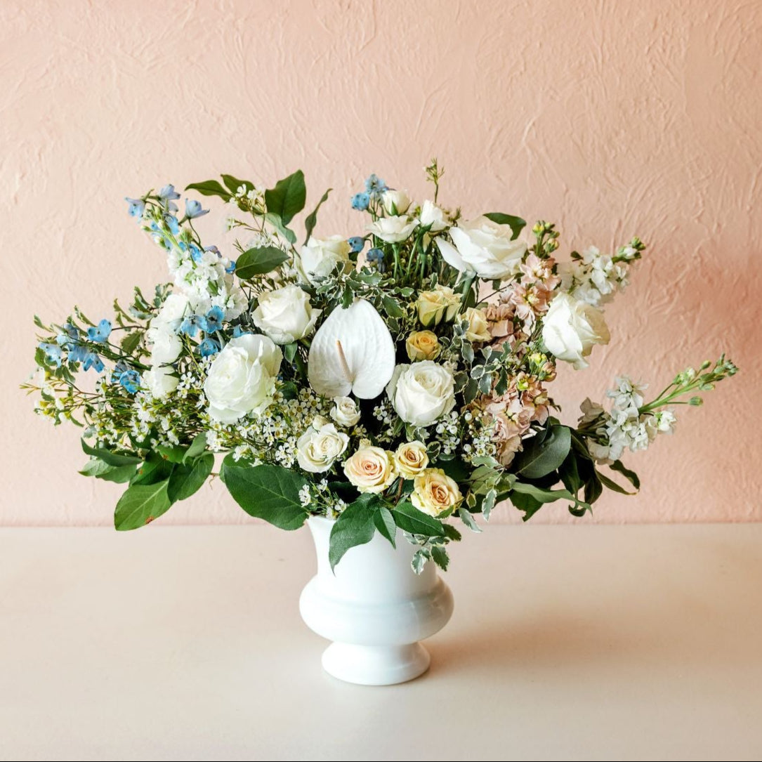 a gorgeous arrangement of fresh flowers in a classic white urn