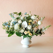 a gorgeous arrangement of fresh flowers in a classic white urn