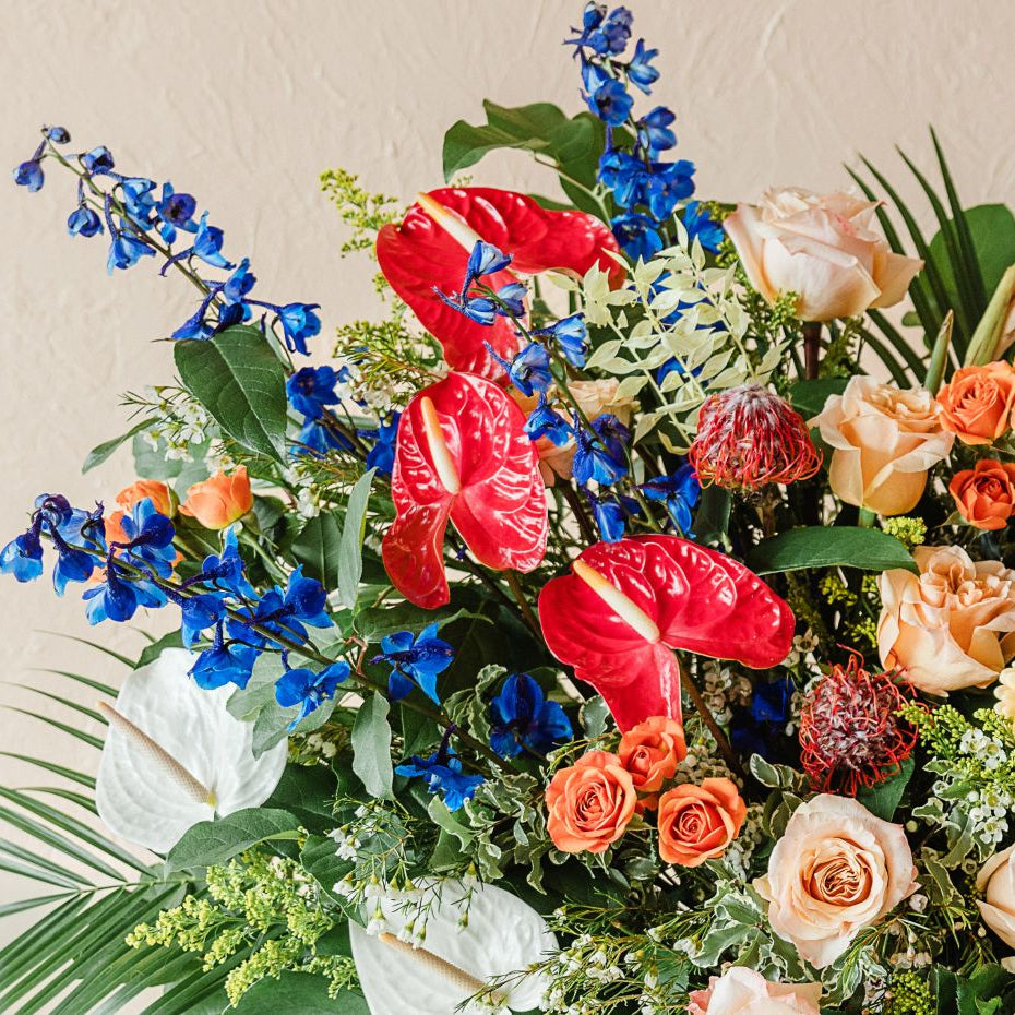 anthurium, delphinium, roses, and palm fronds