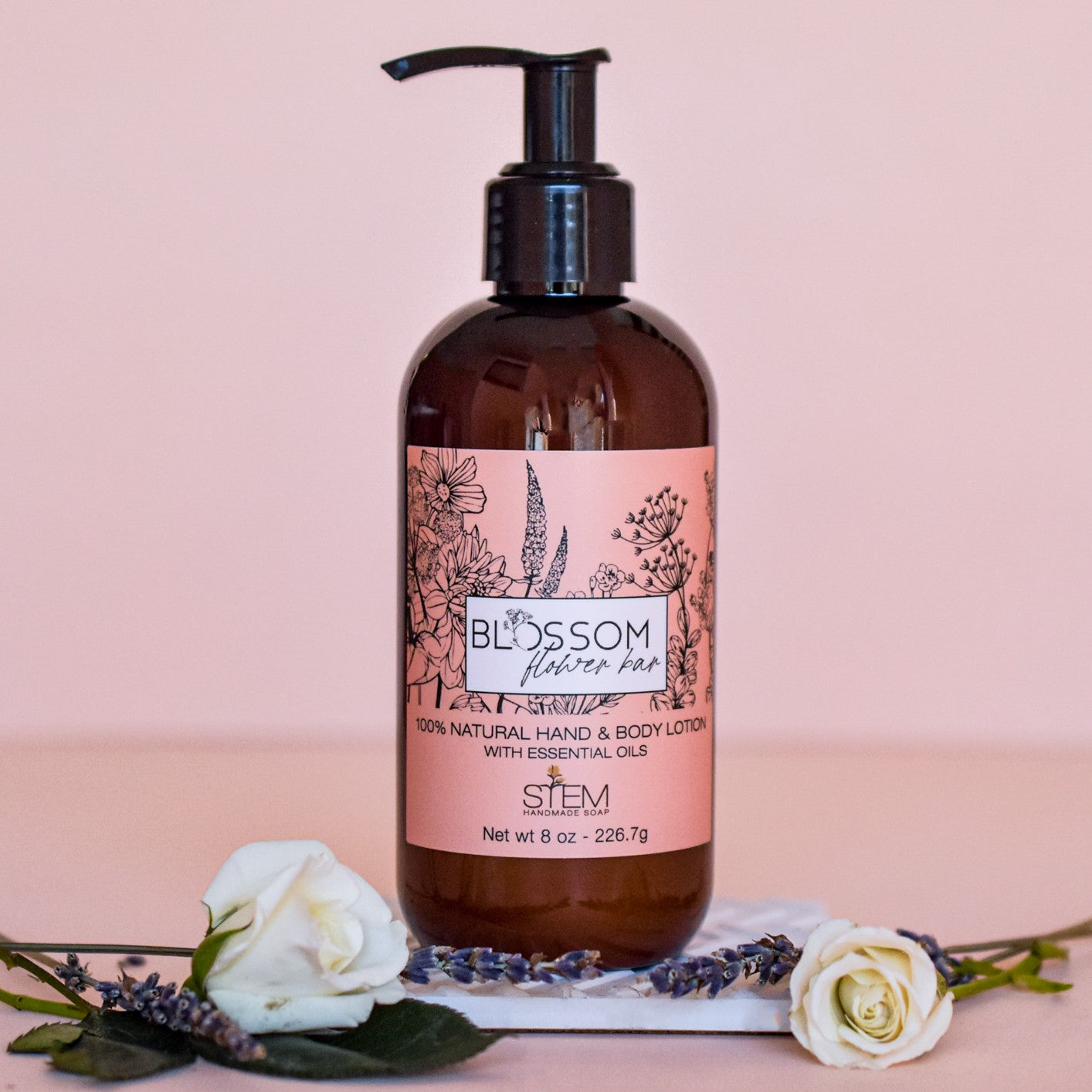 A jar of hand and body lotion staged with flowers and lavender
