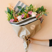 a fun and eclectic wrapped bouquet designed with fresh and seasonal blooms