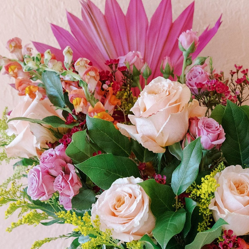 snapdragons, roses, spray roses, waxflower, solidago and a colorful palm fan are custom designed in Cleveland 