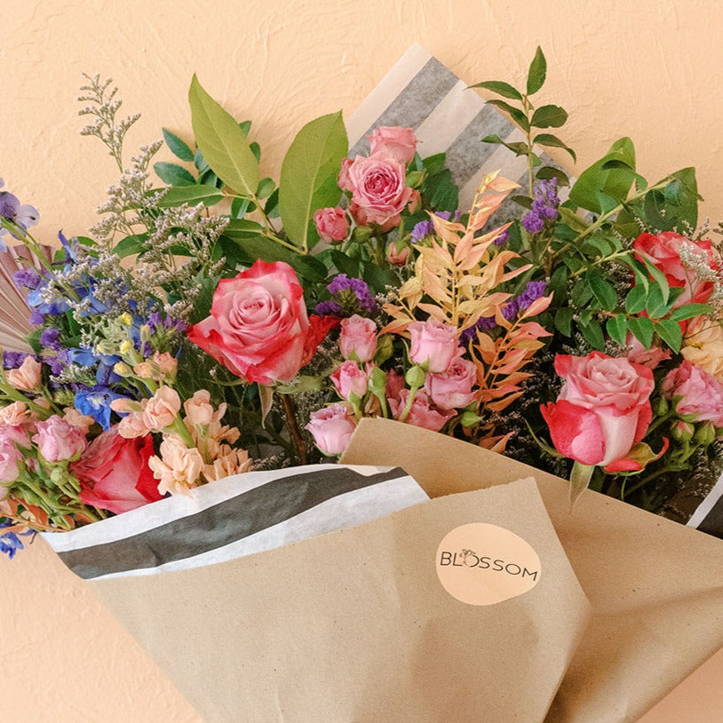 Variegated roses, spray roses, stock, ruscus, limonium are wrapped for gifting