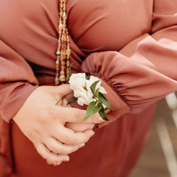 Woman wearing a cuff corsage of white flowers and leaves