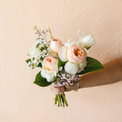 A nosegay bouquet with roses, waxflower and fresh green leaves