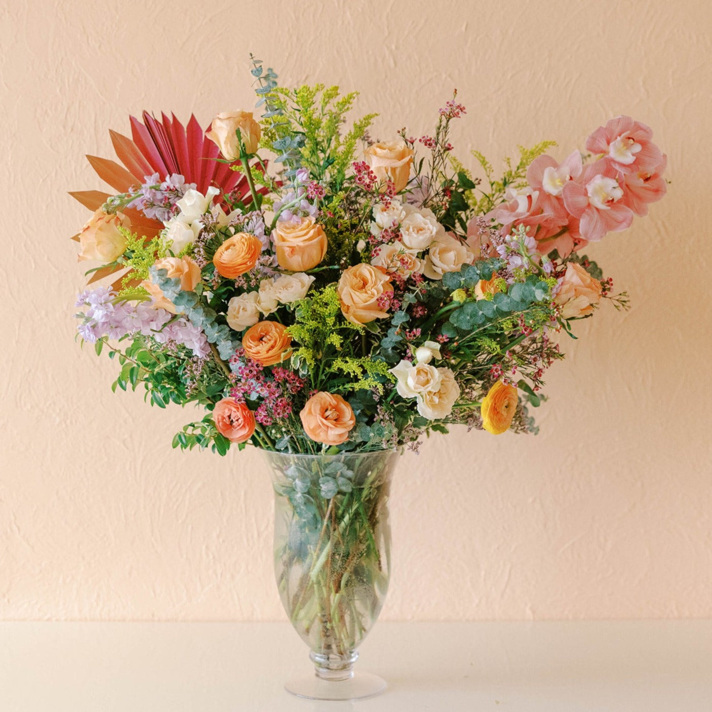 a very large arrangement designed to impress with orchids, roses, eucalyptus and more