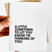 black text on a white card reads "a little something to let you know I'm thinking of you"