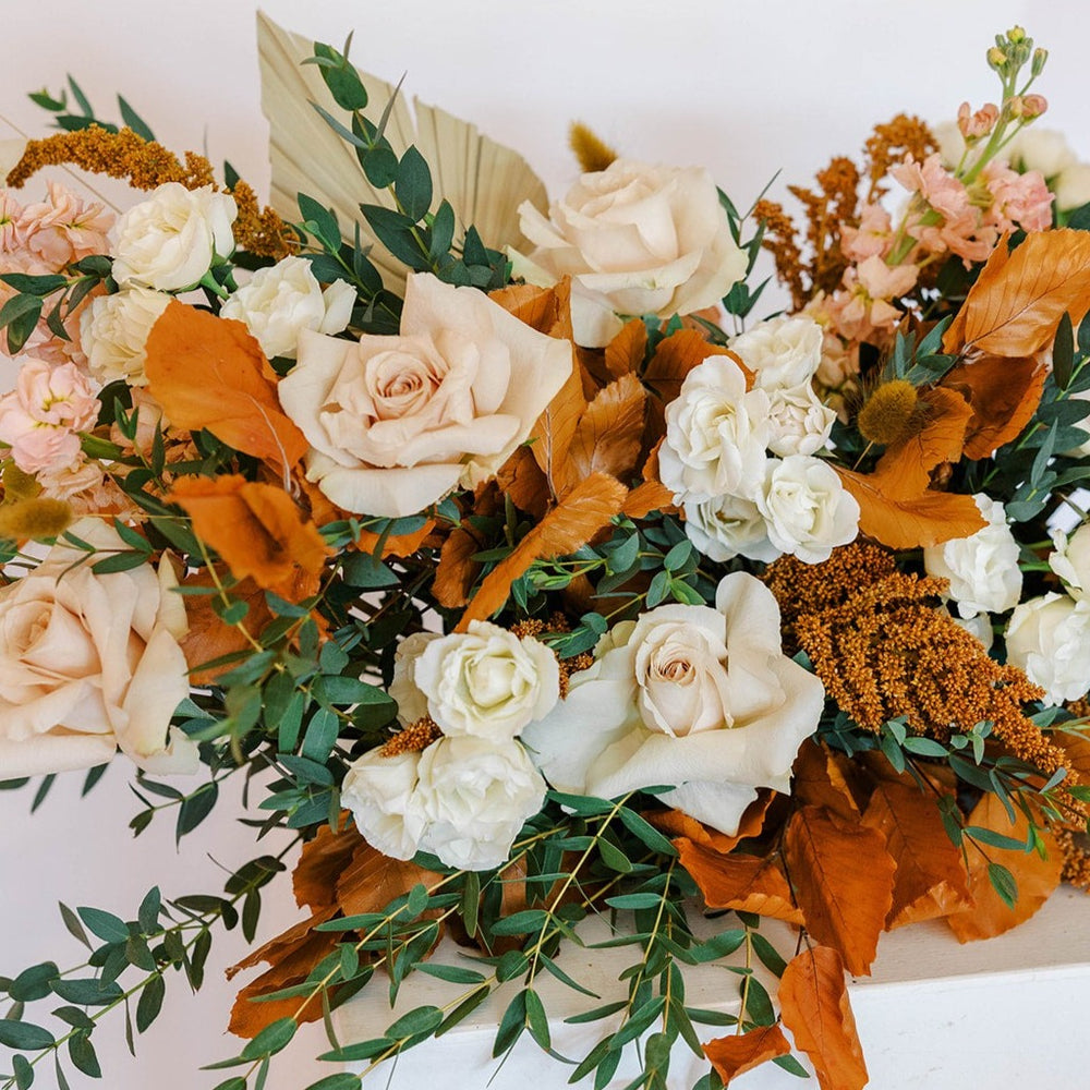 Neutral flowers with fall leaves and greenery