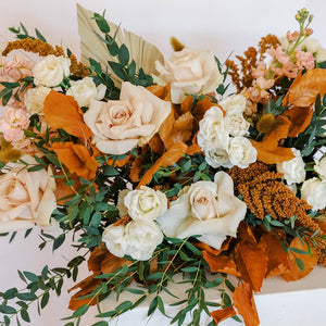 Neutral flowers with fall leaves and greenery