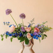 hands hold a beautiful vase of spring flowers