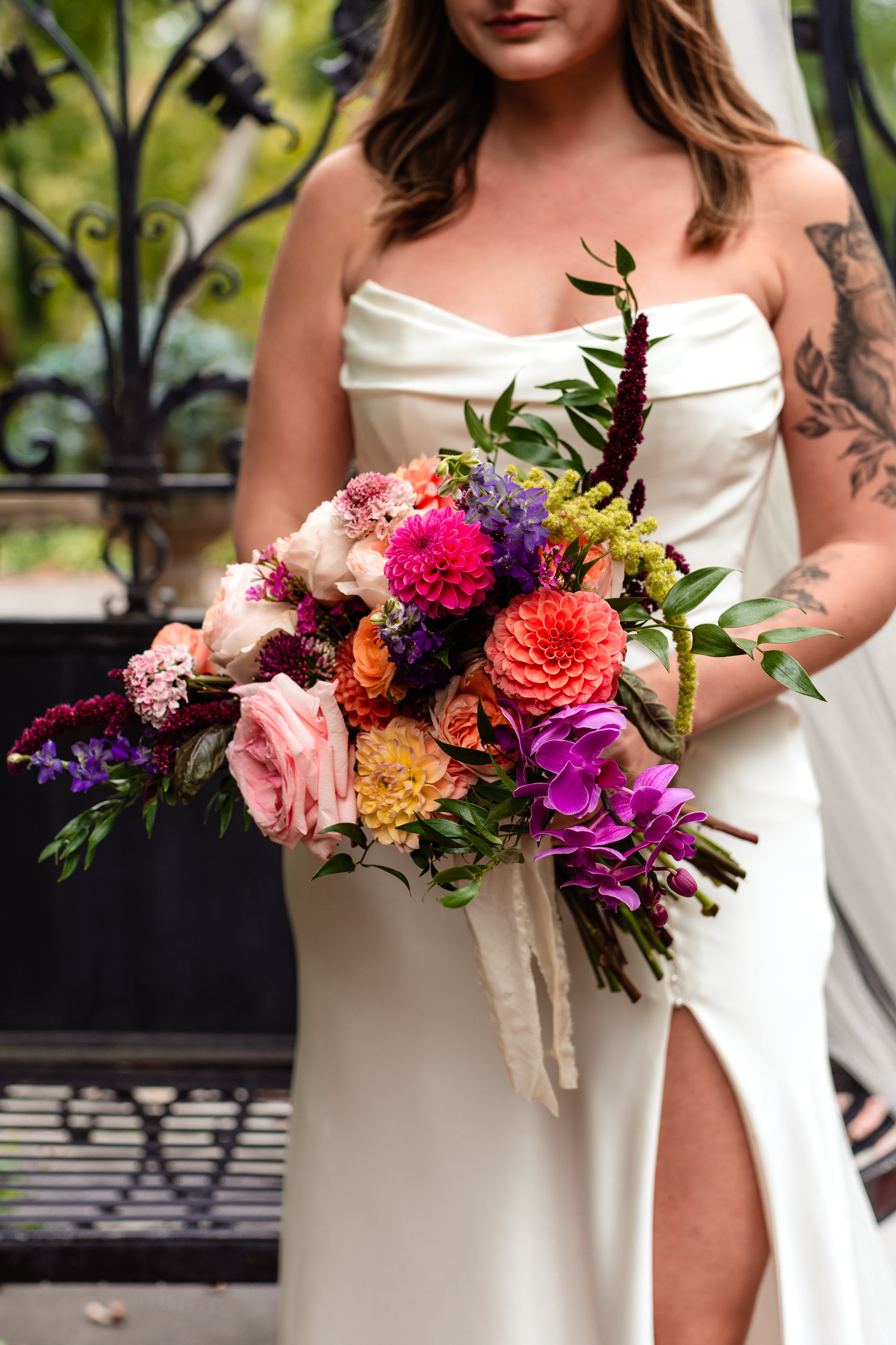 A bride holds a bright and colorful bouquet for her wedding