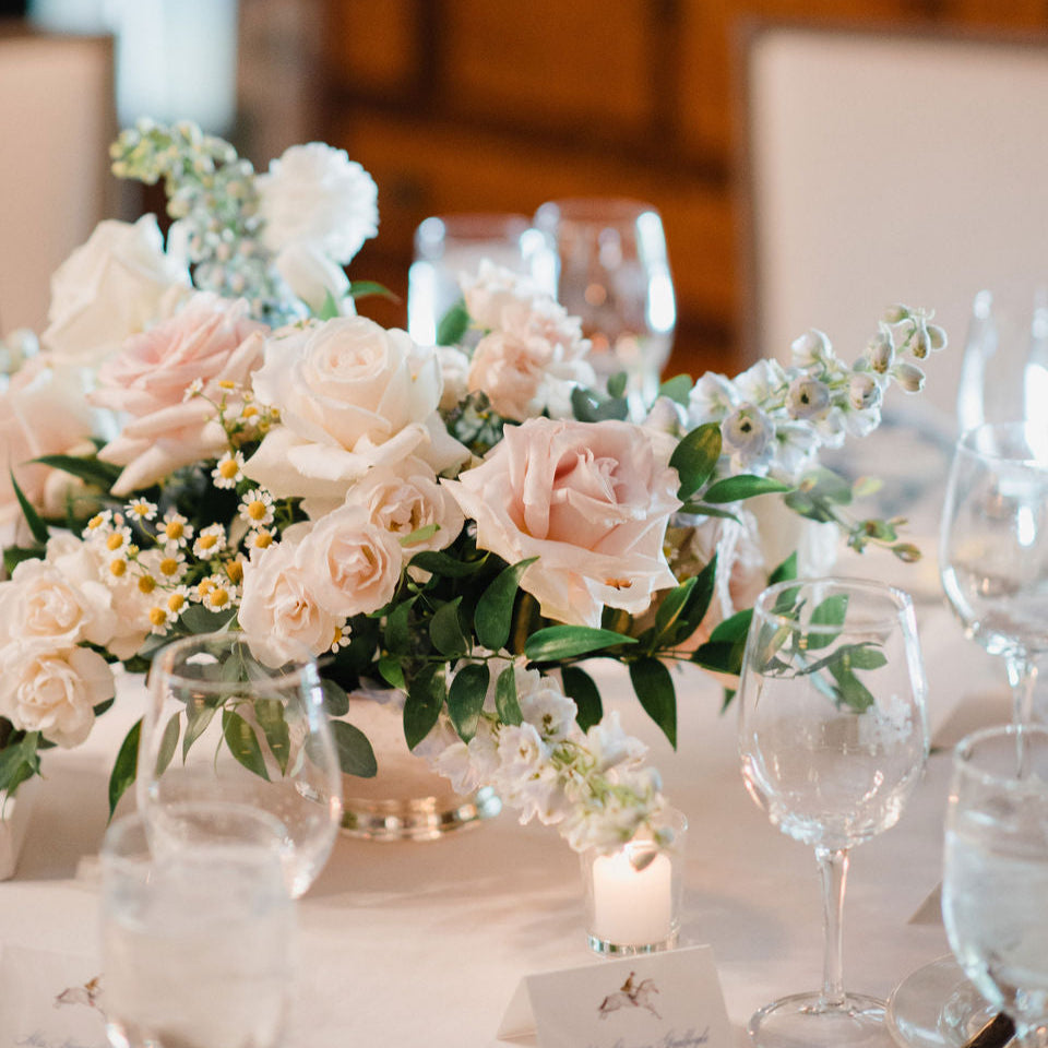 a gorgeous centerpiece with chamomile, roses, spray roses 