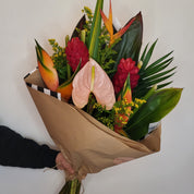 Blossom's designers created a bouquet of orange and dark green tropical flowers including ginger and bird of paradise