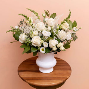 White sympathy floral arrangement with white vase