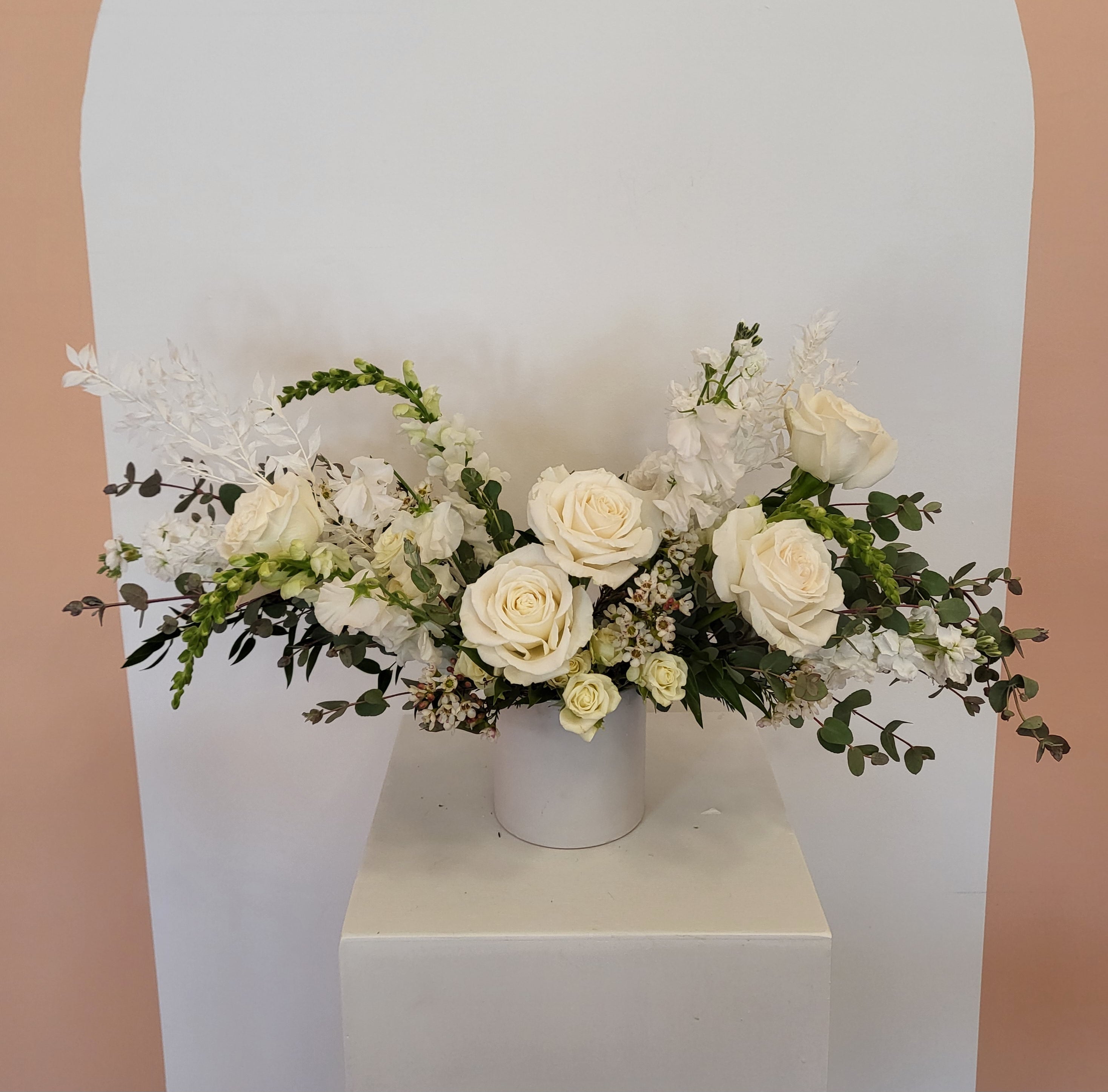 an elegant white centerpiece with greens is great for a summer, winter, fall or spring wedding