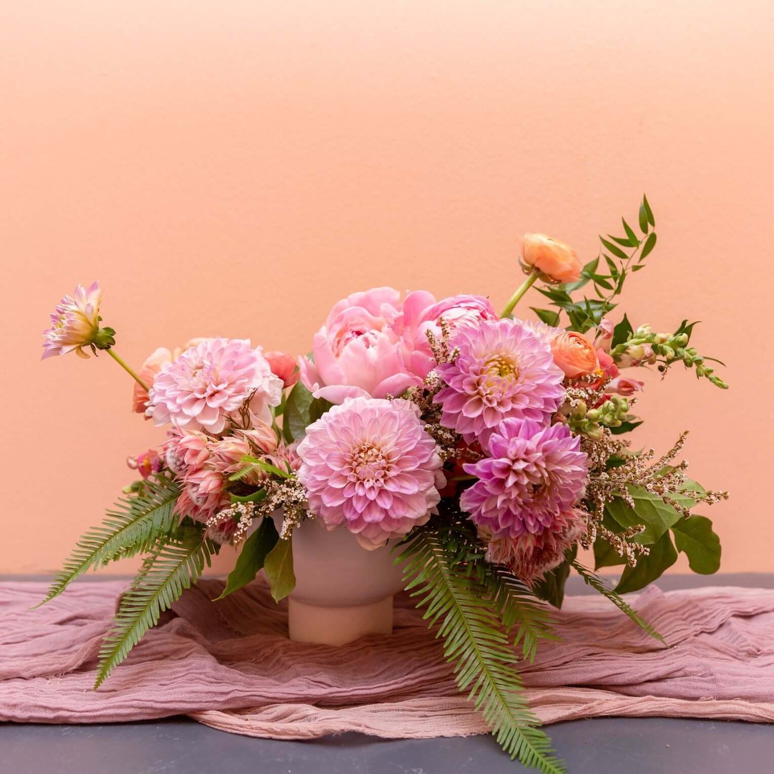 fill a table with cheerful pink flower dahlias and peonies