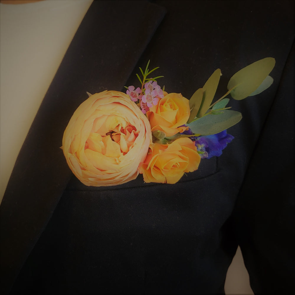 multicolored pocket floral boutonniere in suit breast pocket with eucalyptus
