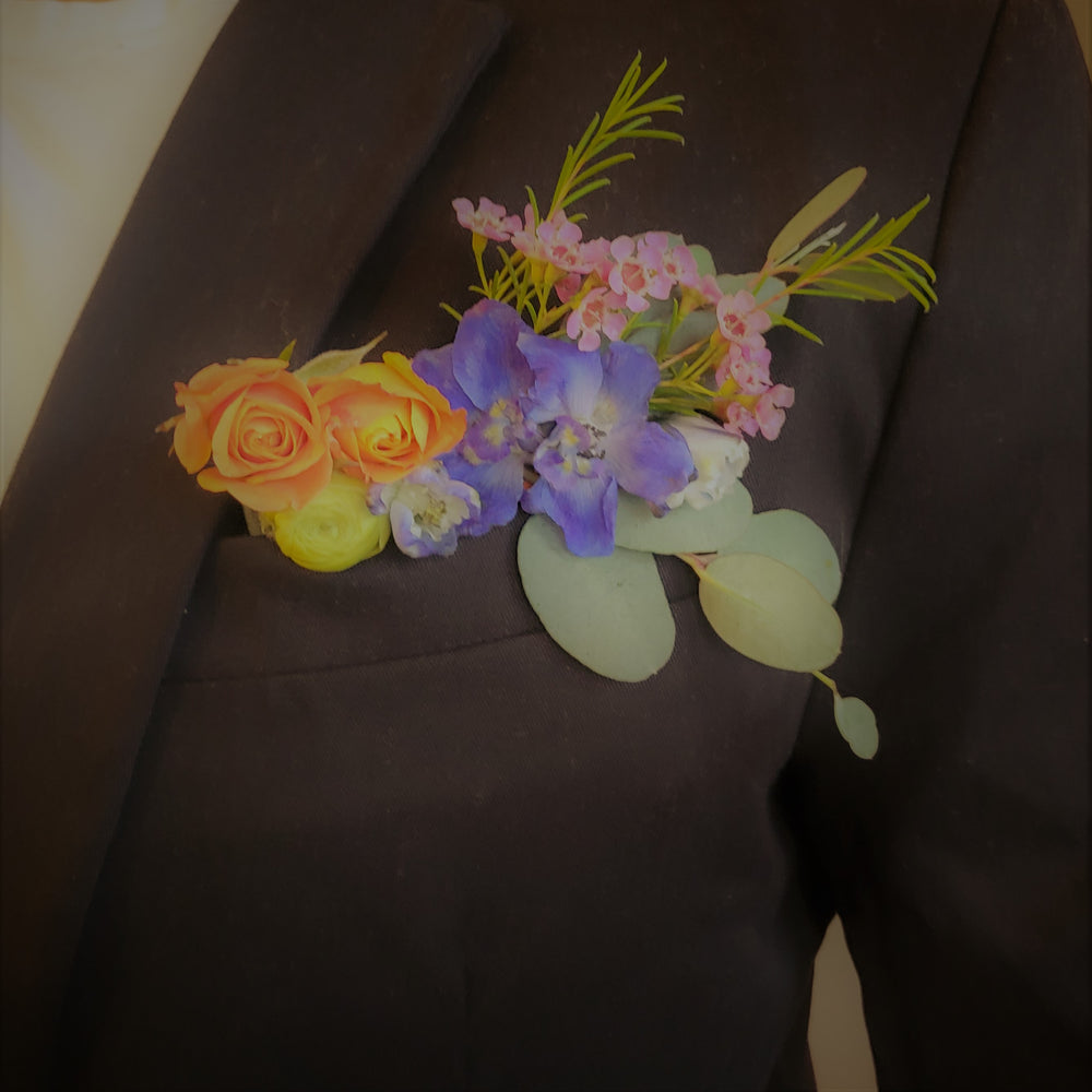 multicolored pocket floral boutonniere in suit breast pocket.